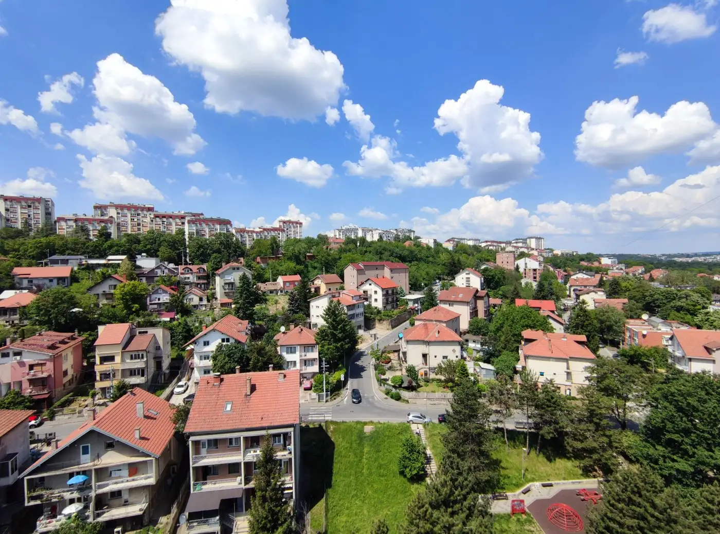 Vista aérea de um bairro planejado moderno com casas verdes e ruas arborizadas